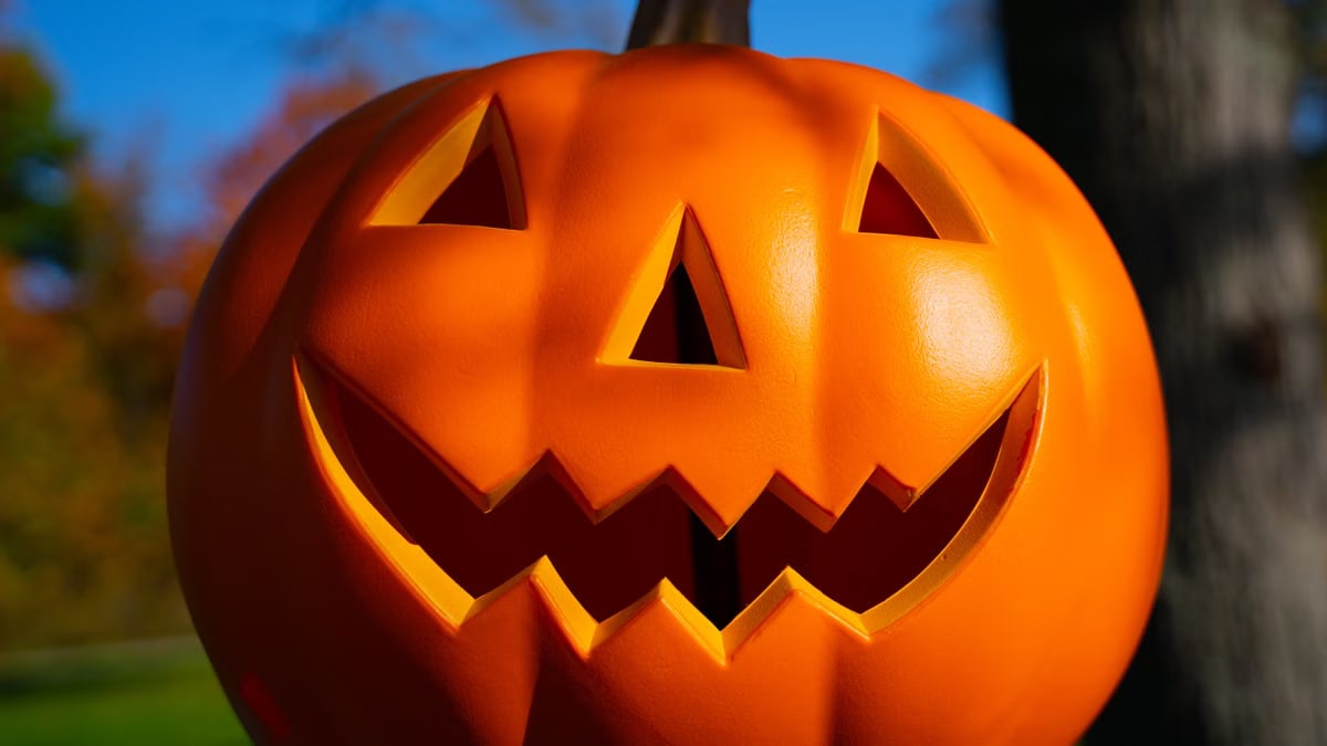 Brightly colored Jack-O'-Lantern with a spooky grin outdoors, perfect for Halloween themes.
